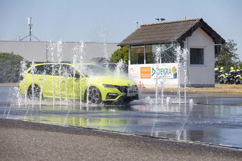 PKW fährt beim Training durch eine Wand aus Wasser.
